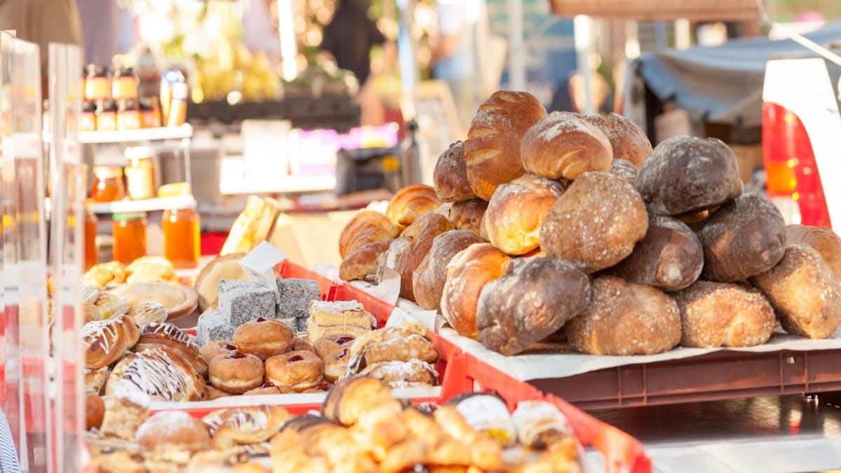 Fresh breads and pastries on display at a market stall.