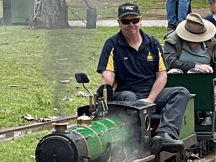 Man driving miniature steam train