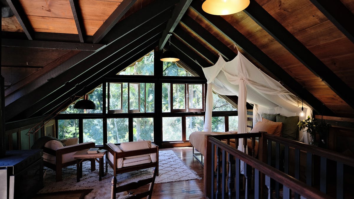 Open plan bedroom with large windows and fireplace.