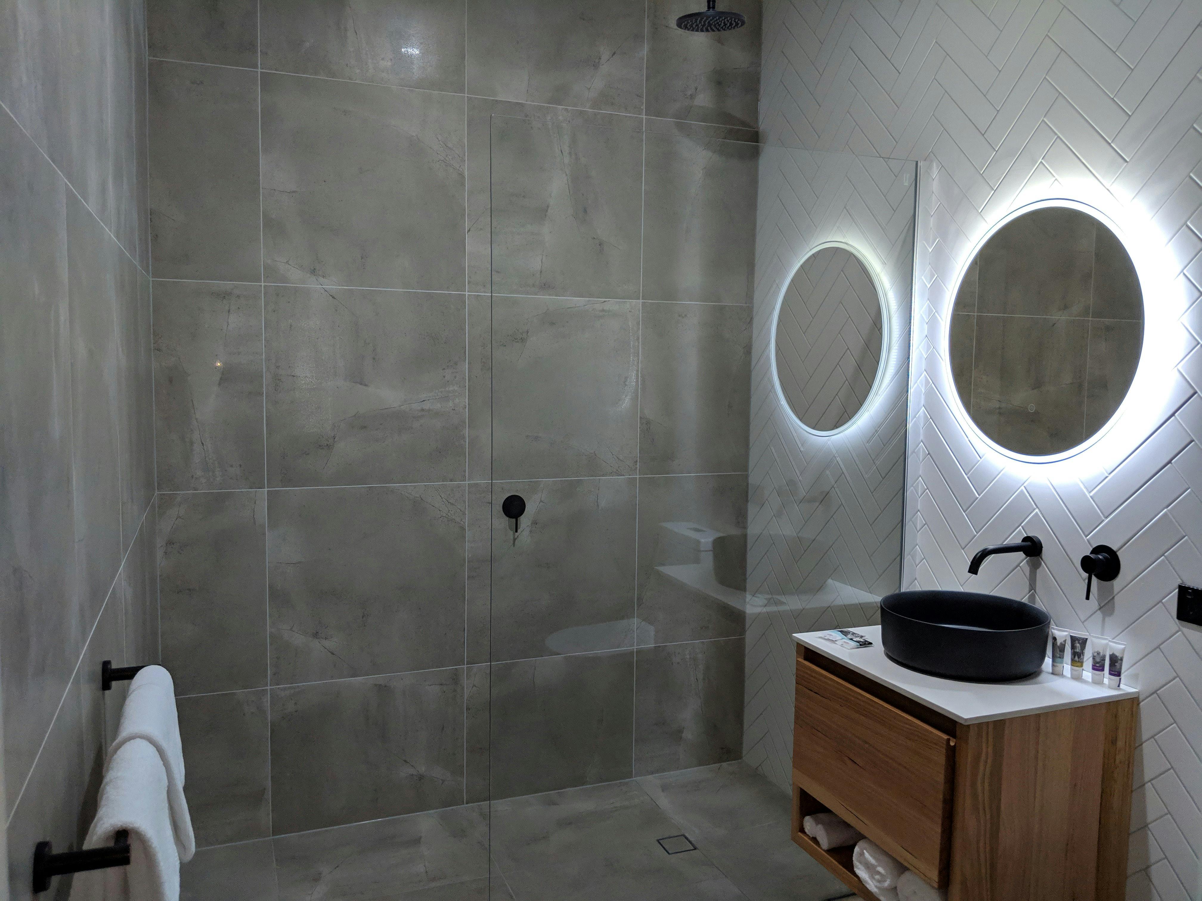Modern bathroom showing shower and basin with mirror.