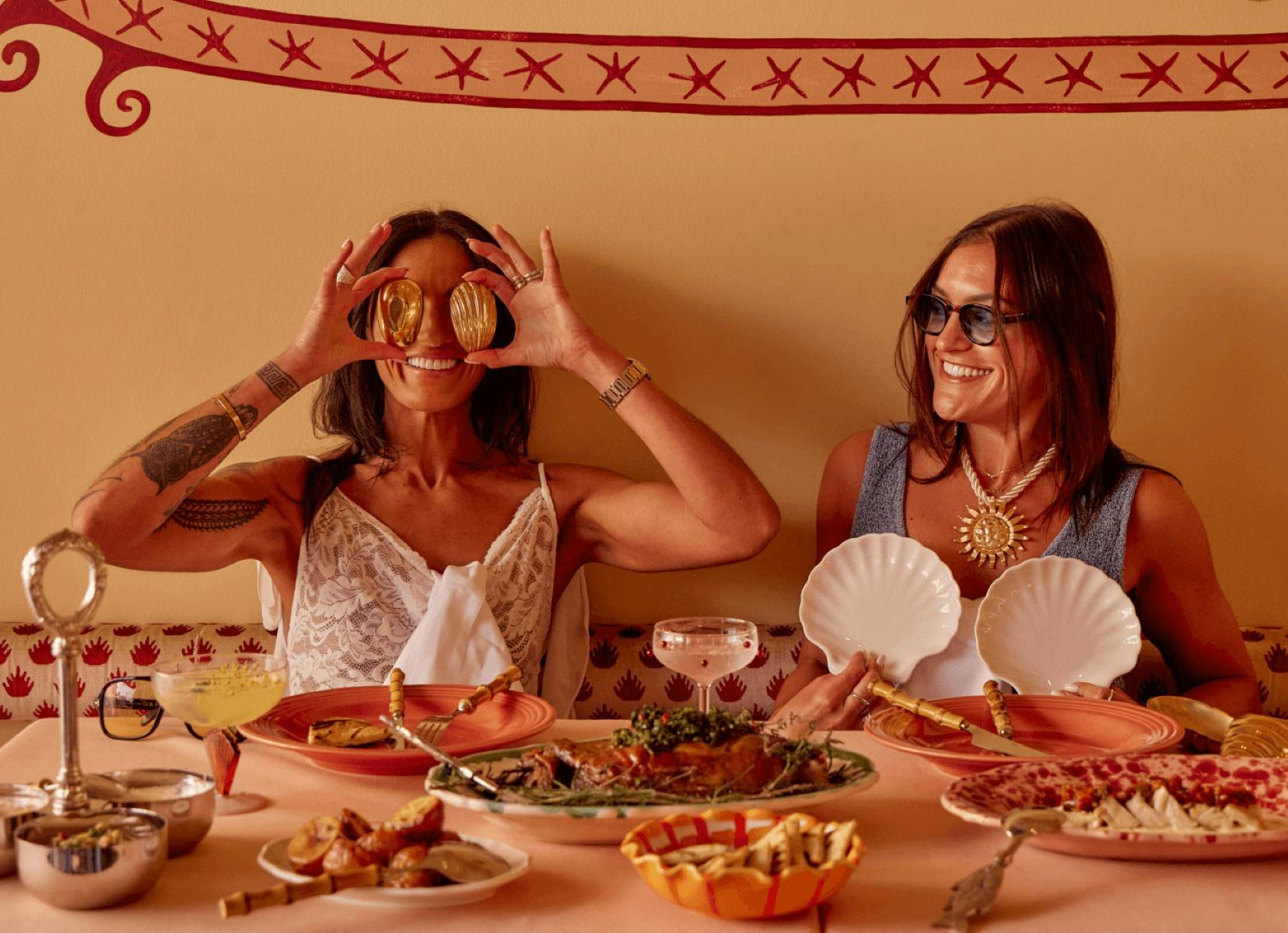 two ladies smiling holding shells at Akti Greek Restaurant Woolloomooloo Sydney