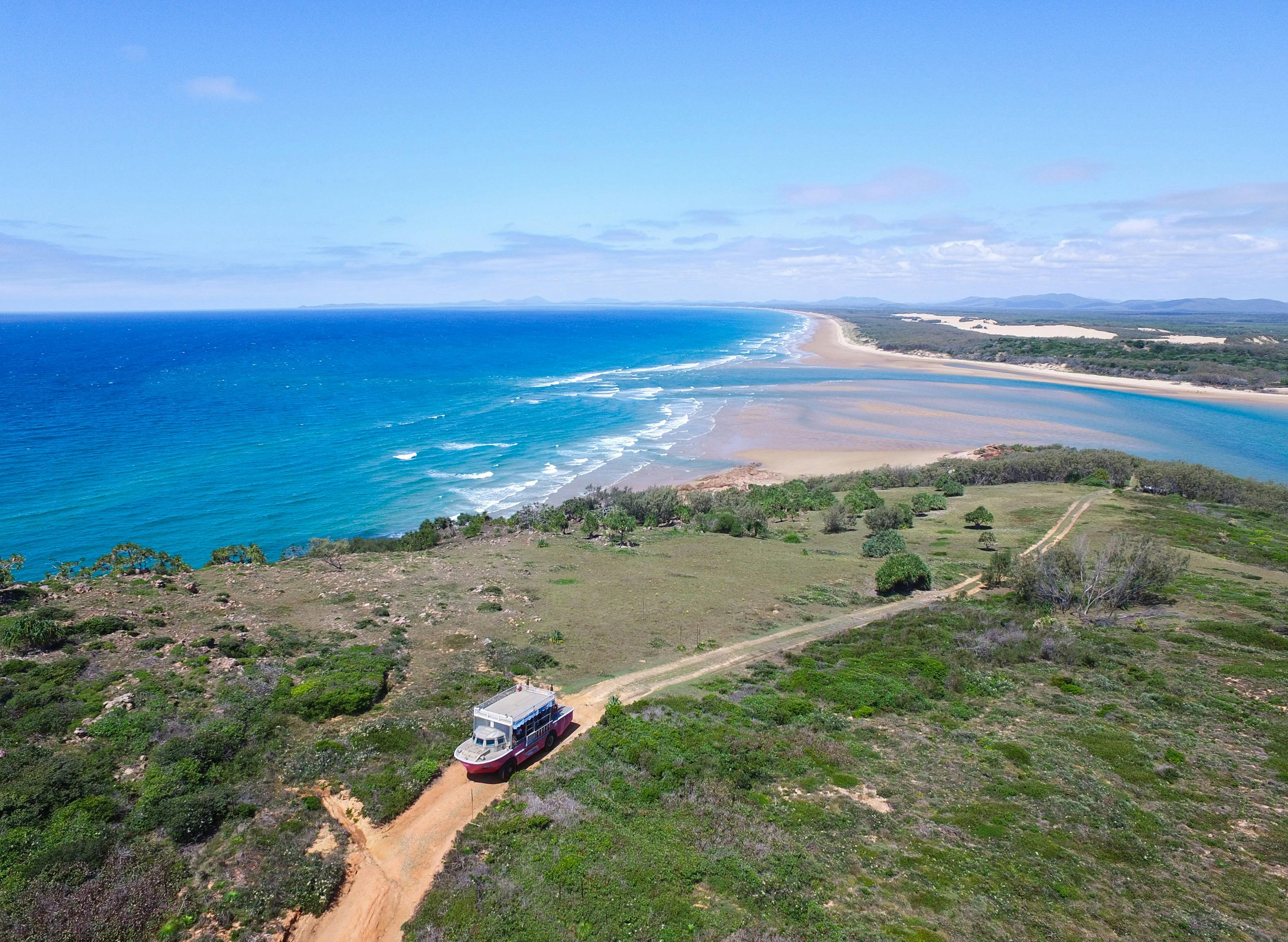 Pink amphbious vehicle driving up steep headland