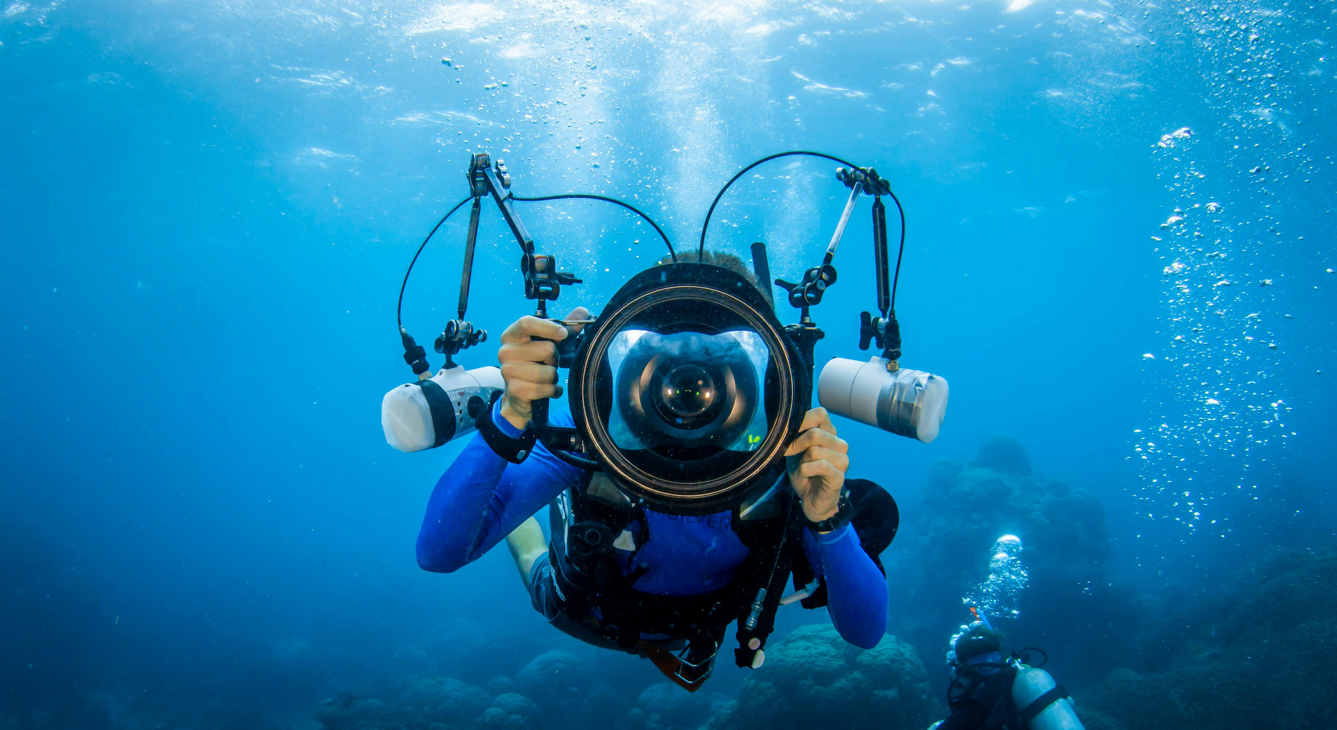 Photographer in the water holding a massive camera