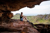 A woman sits inside a cave on tour in Chillagoe-Mungana Caves National Park, North Queensland.