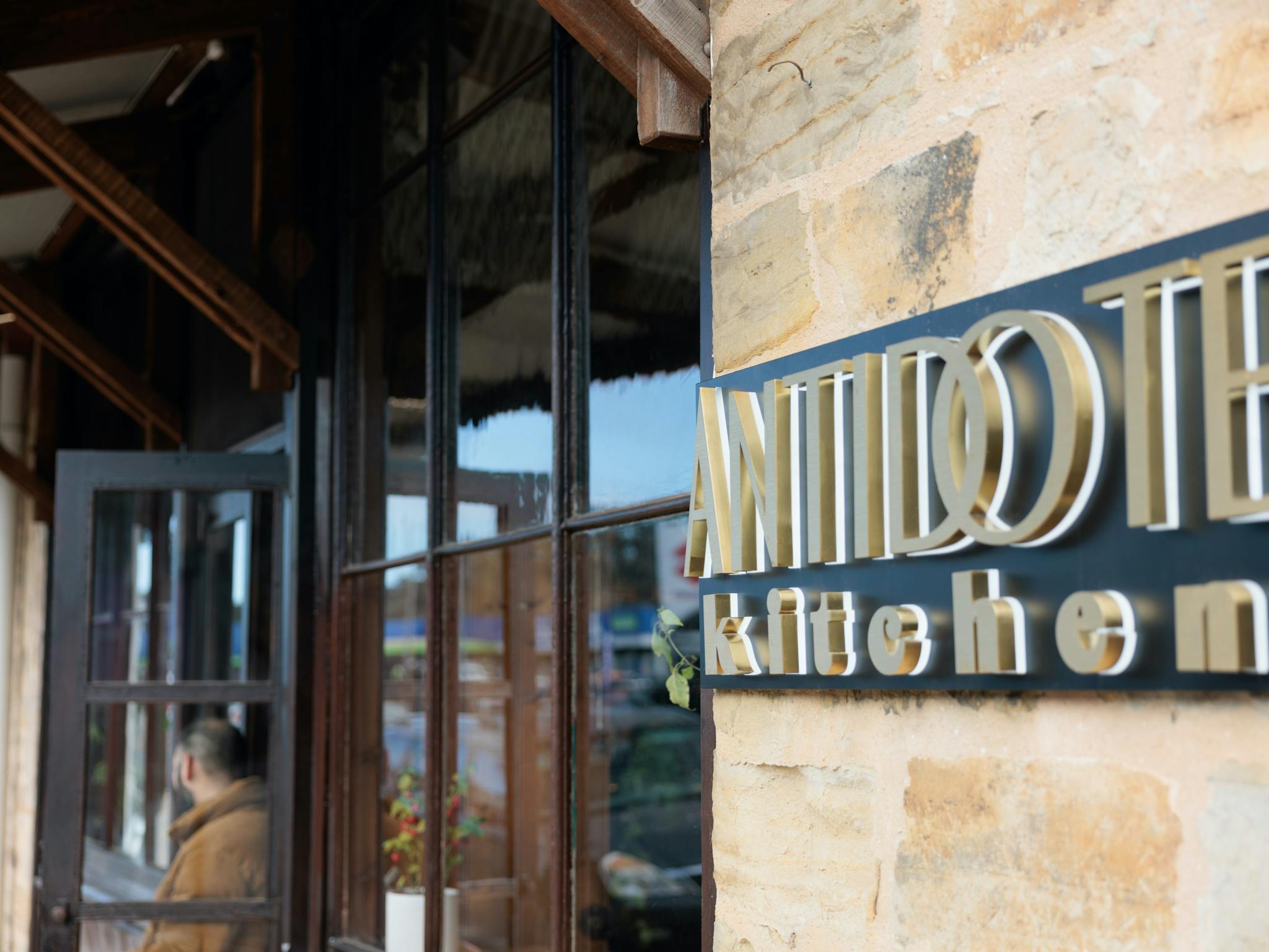 Photo of restaurant front with restaurant sign in forefront