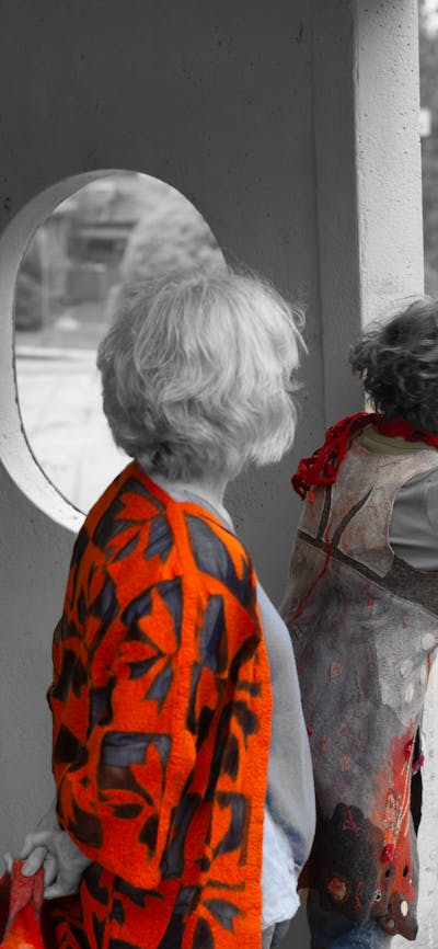 Two women dressed in orange felt at a bus stop in Canberra.