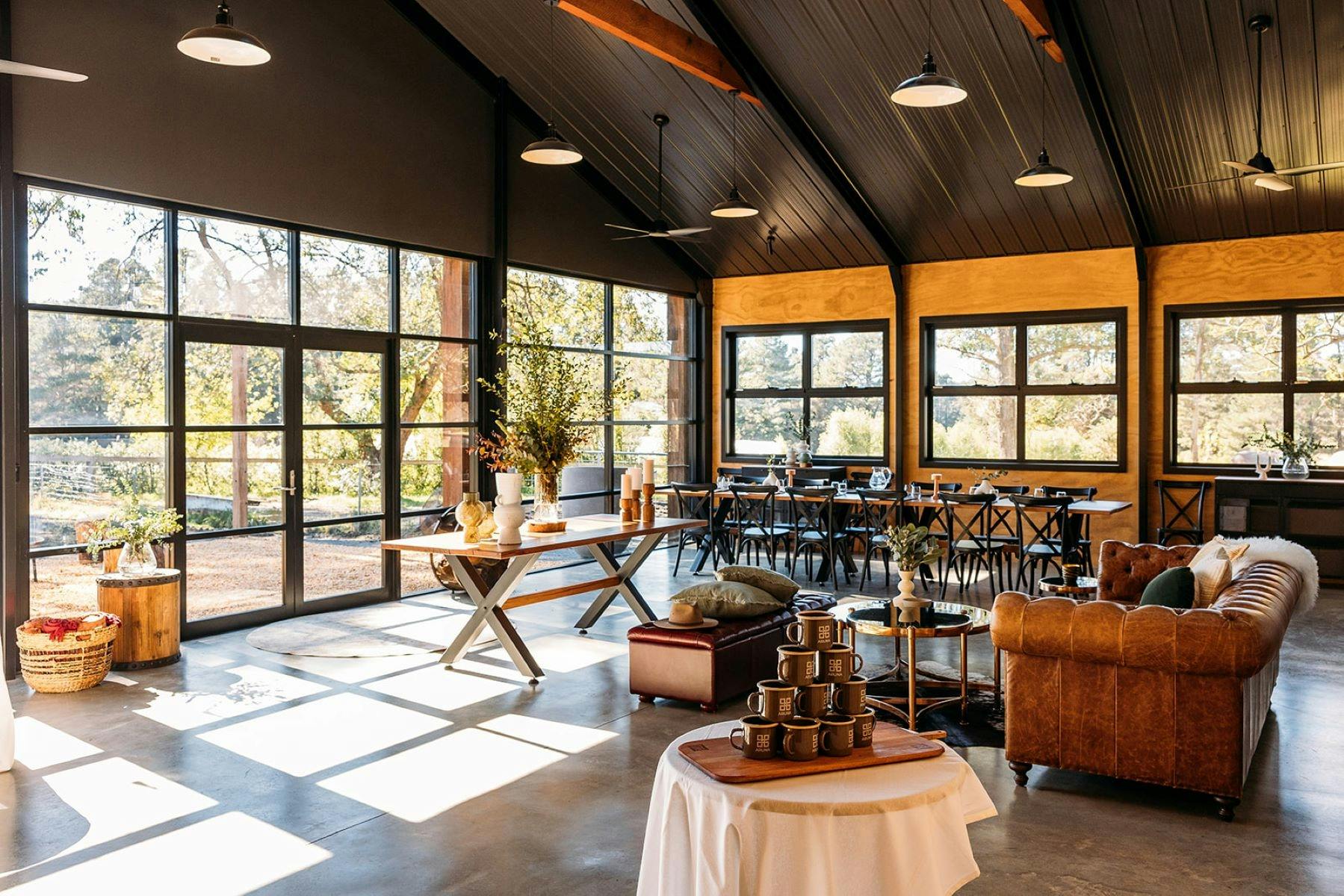 Inside of The Stables event building showing the interior designed layout of tables for work meeting