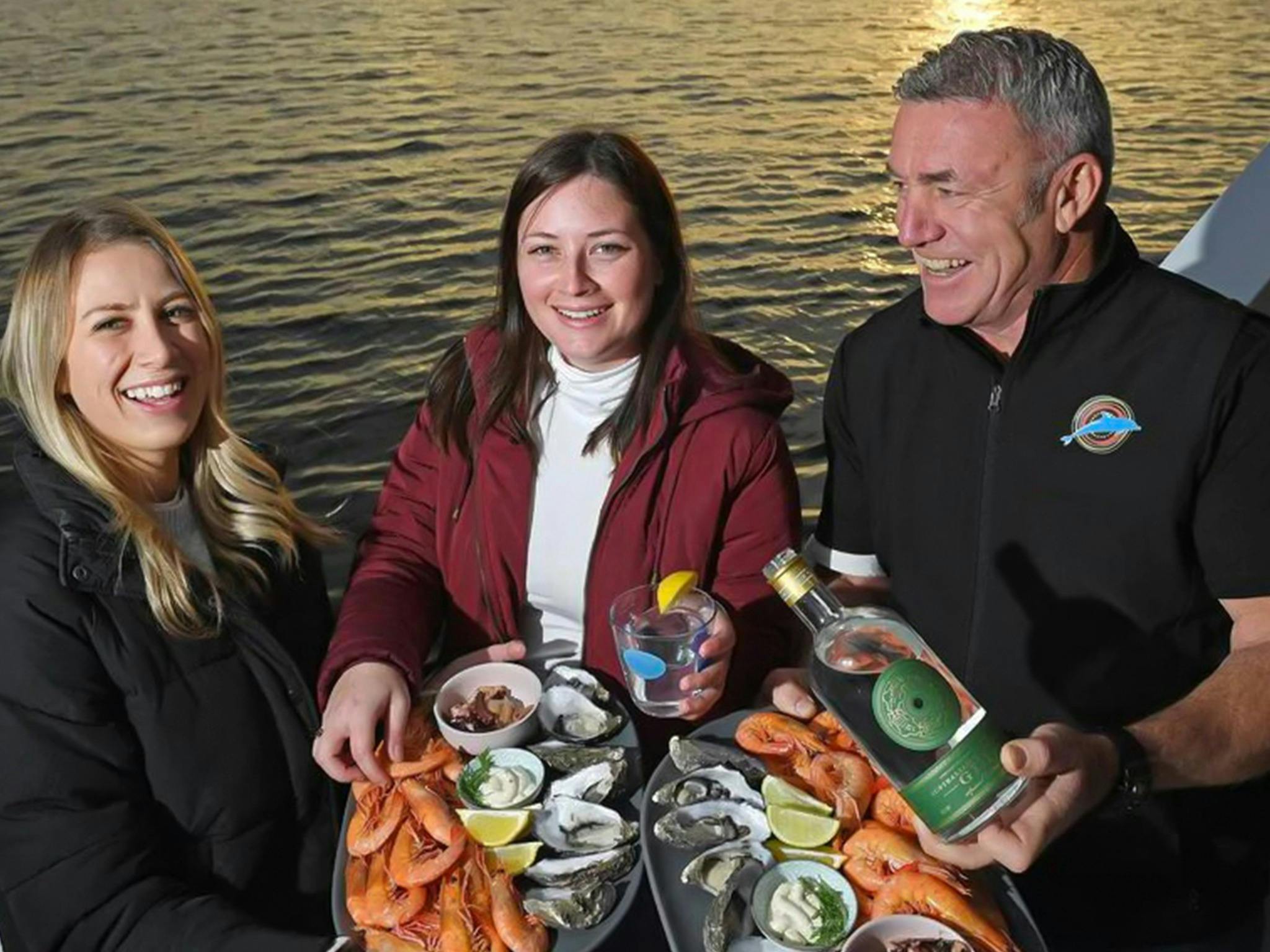 Passengers enjoy a seafood platter and some local gin on the deck while on a private cruise