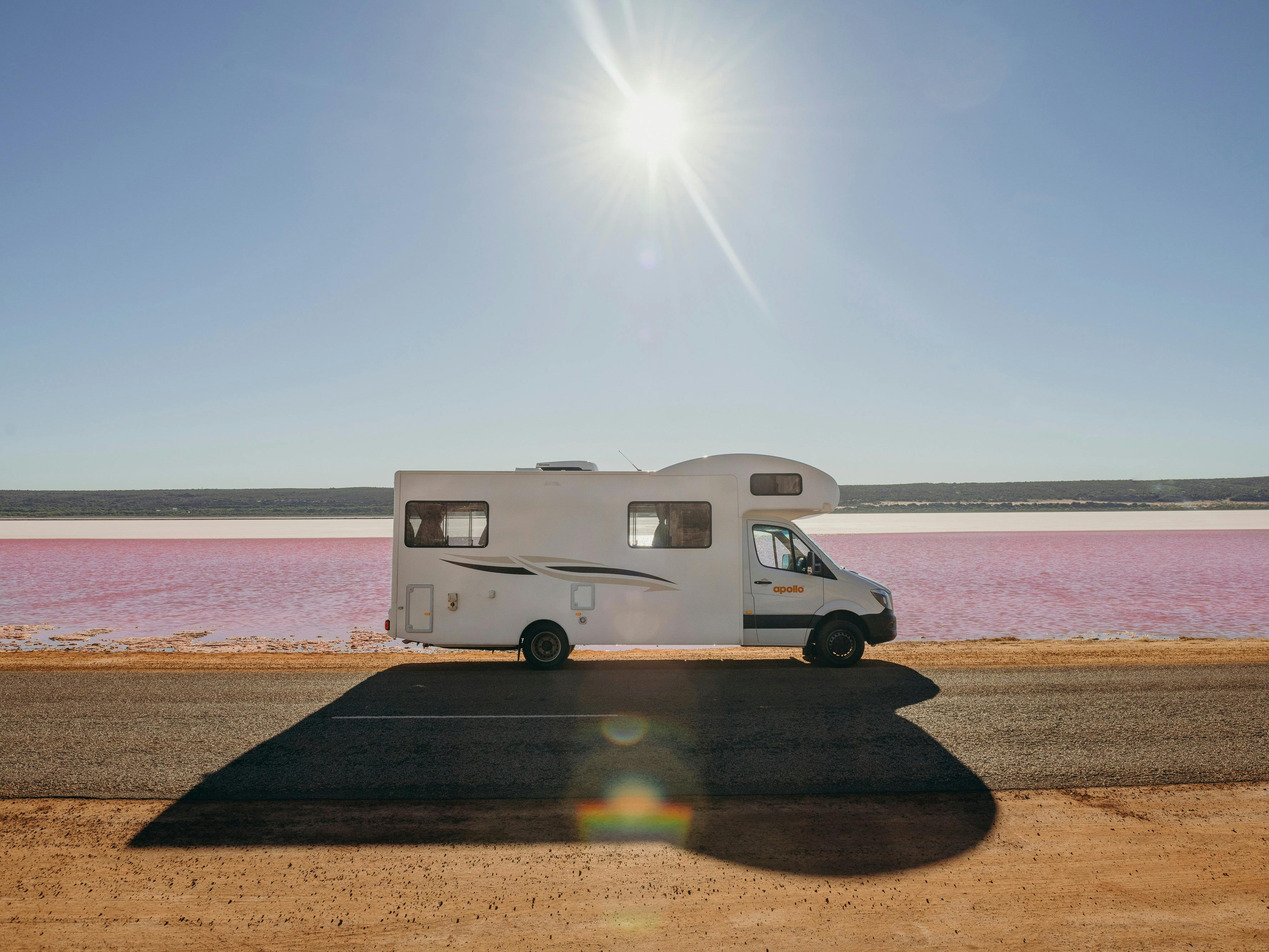 A motorhome is parked next to the purple salt flats
