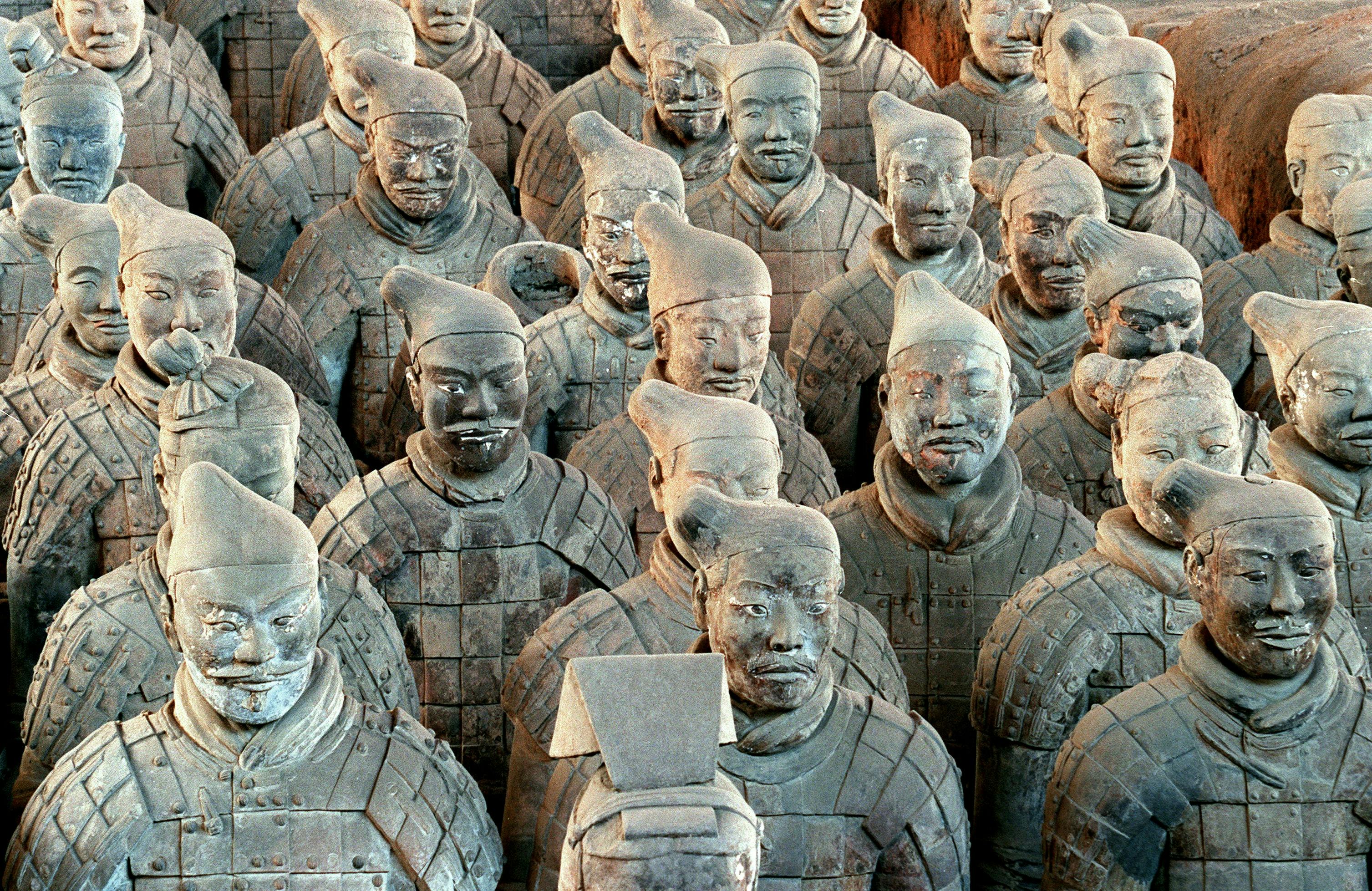 A large formation of terracotta warrior statues in uniform standing in rows.