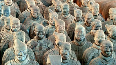 A large formation of terracotta warrior statues in uniform standing in rows.