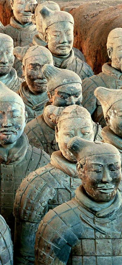 A large formation of terracotta warrior statues in uniform standing in rows.