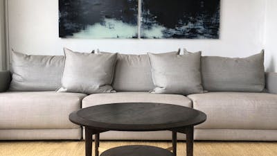 Grey sofa on a jute rug, with walnut coffee table.