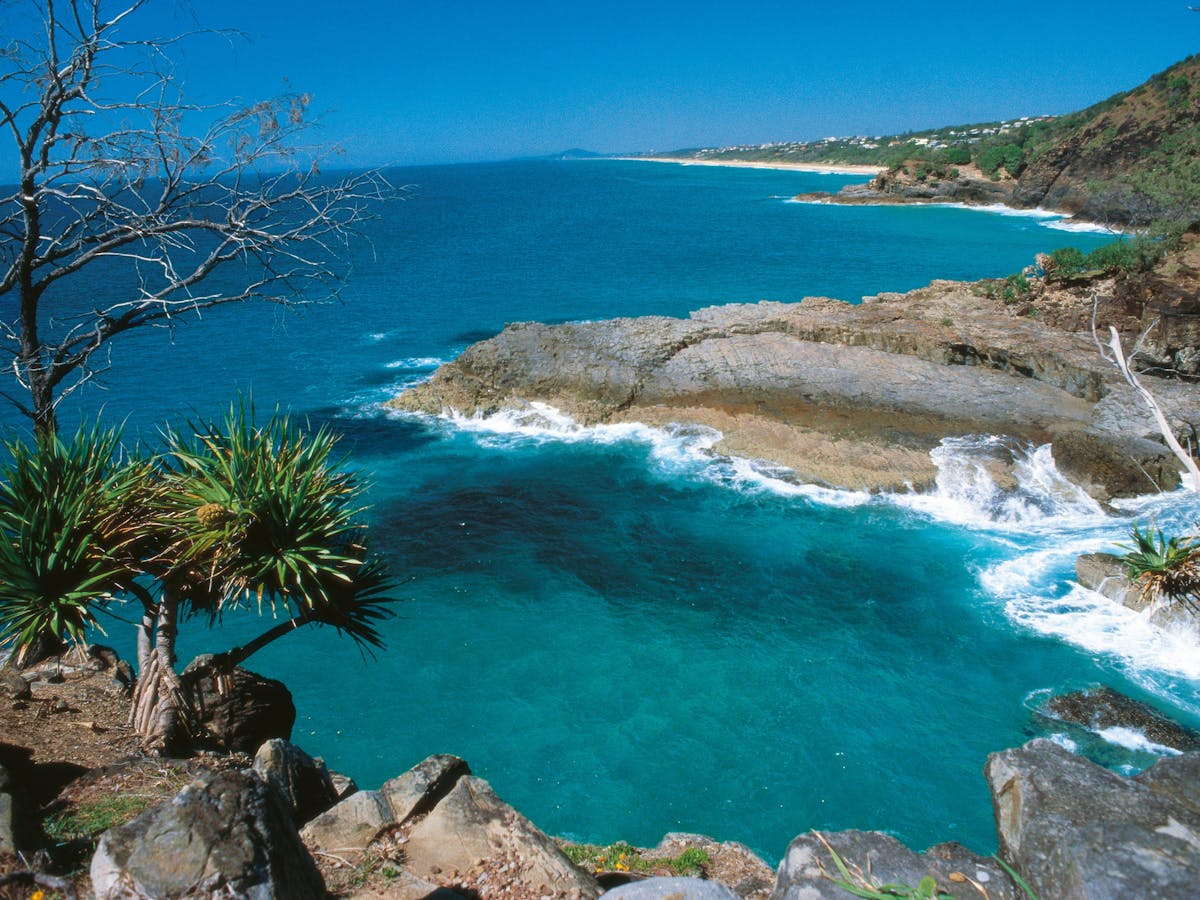 View over ocean and rocky promontory under blue sky. View over ocean and rocky promontory under blue sky.