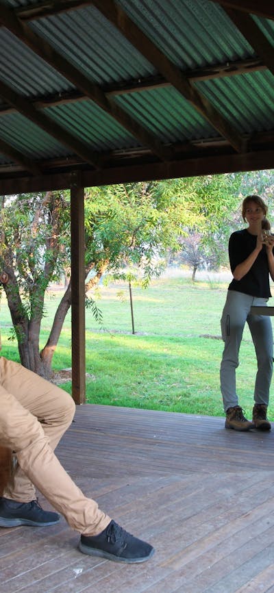 3 people having a BBQ on a verandah