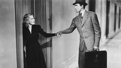 Black and white still of woman pulling a mans wrist to follow her