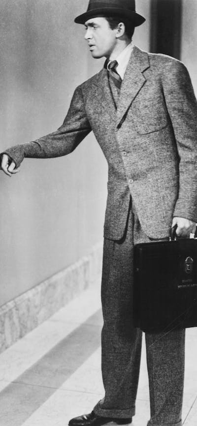 Black and white still of woman pulling a mans wrist to follow her
