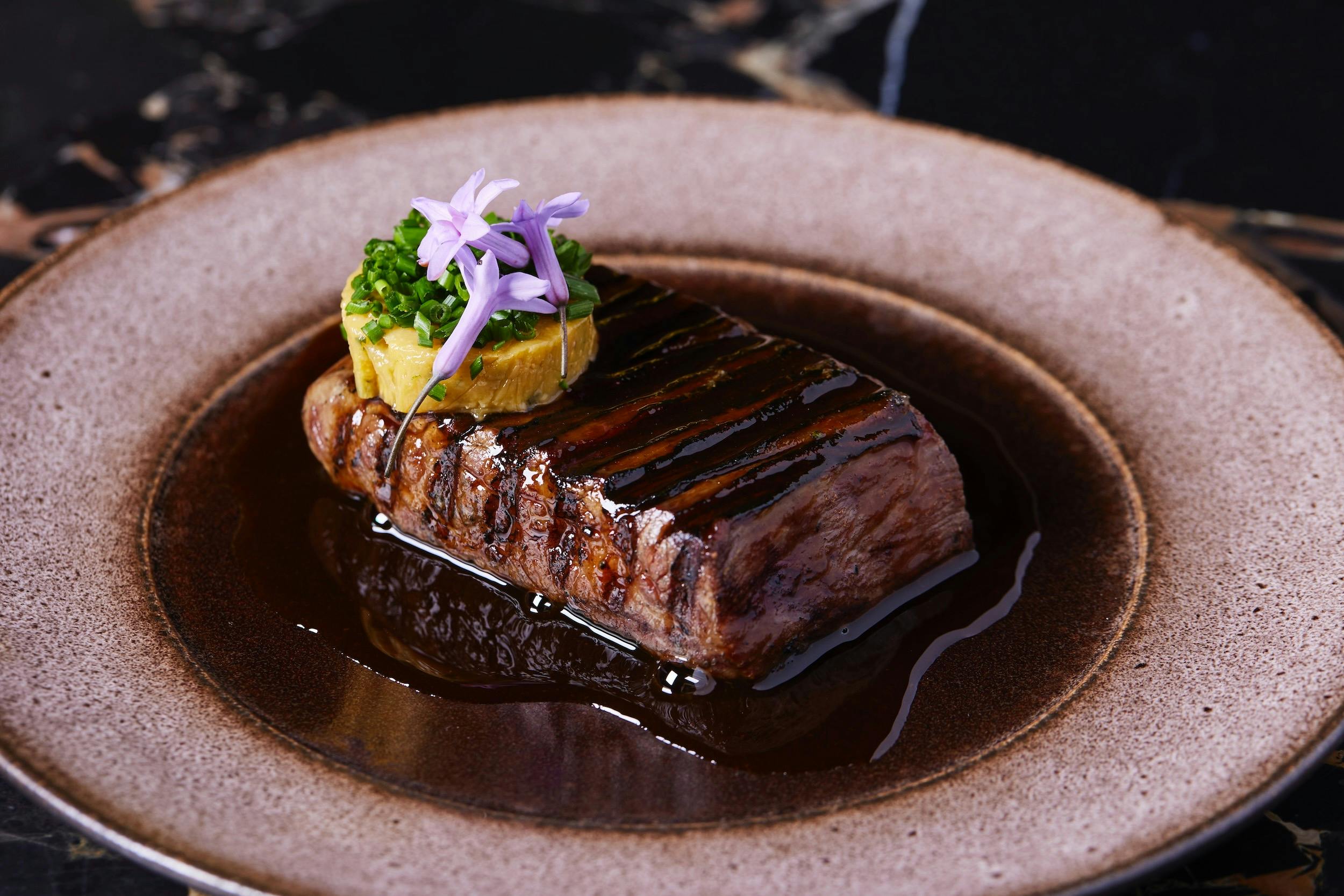 Image of elegantly presented steak dish with a perfect circle of butter on top