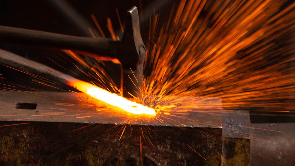 Hammer striking heated metal on anvil creating sparks. Hammer striking heated metal on anvil creating sparks.