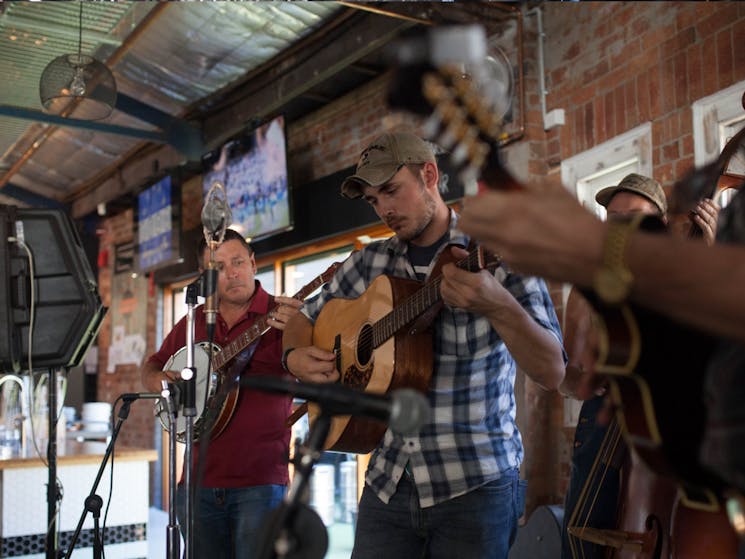 A band playing mandolin, acoustic guitar, banjo and double bass on the FogHorn Brewhouse stage