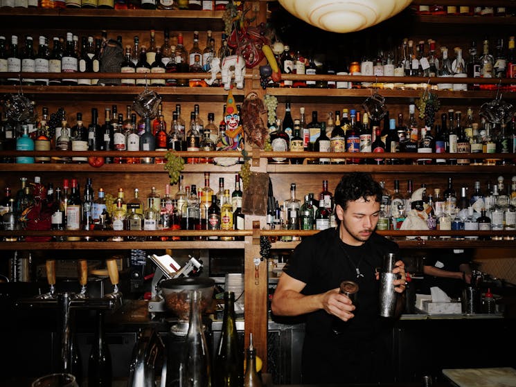 Barman making cocktails in front of a well stacked bar at Alberto's Lounge, Hollywood Quarter, Sydne