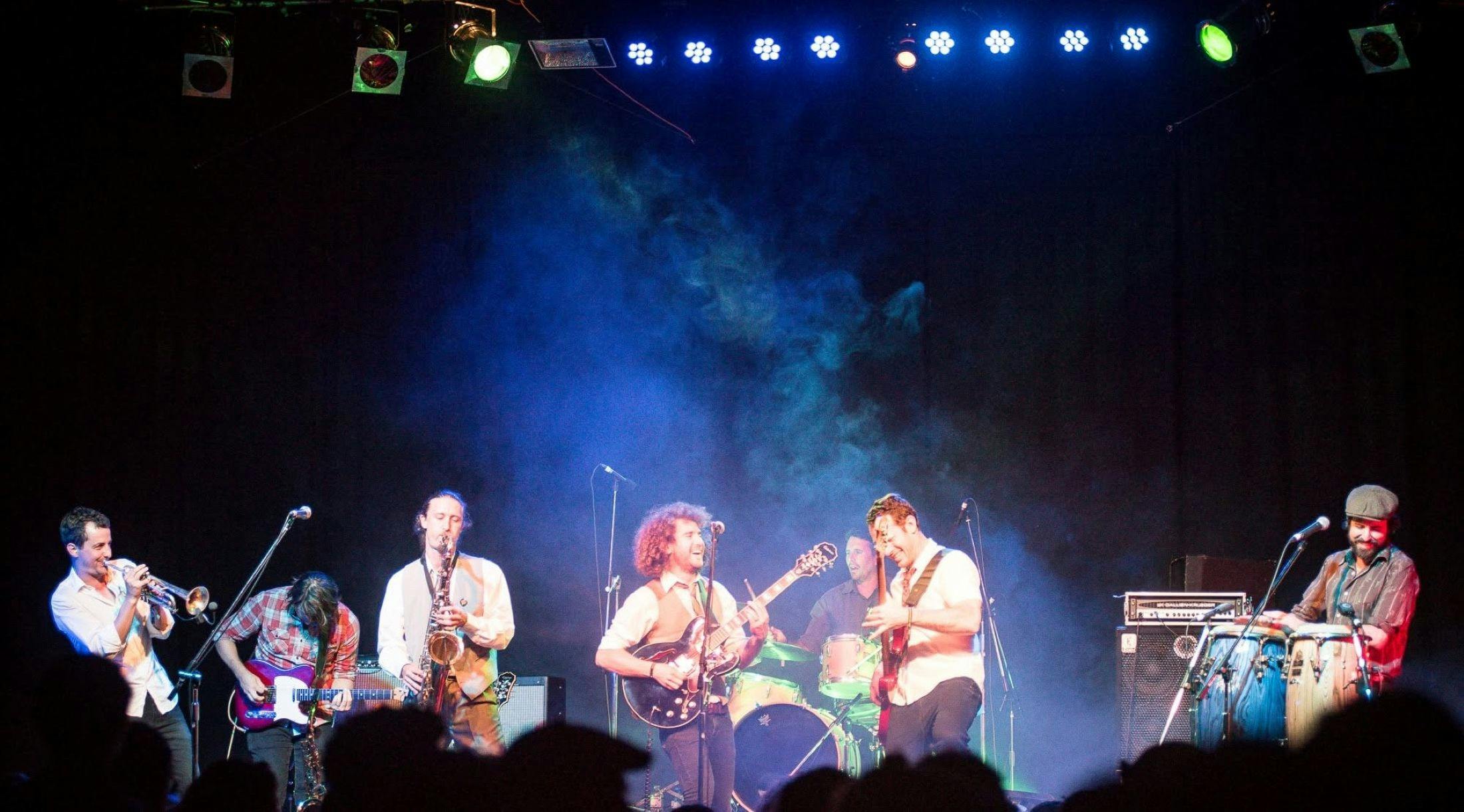 Band playing on stage with blue lights above