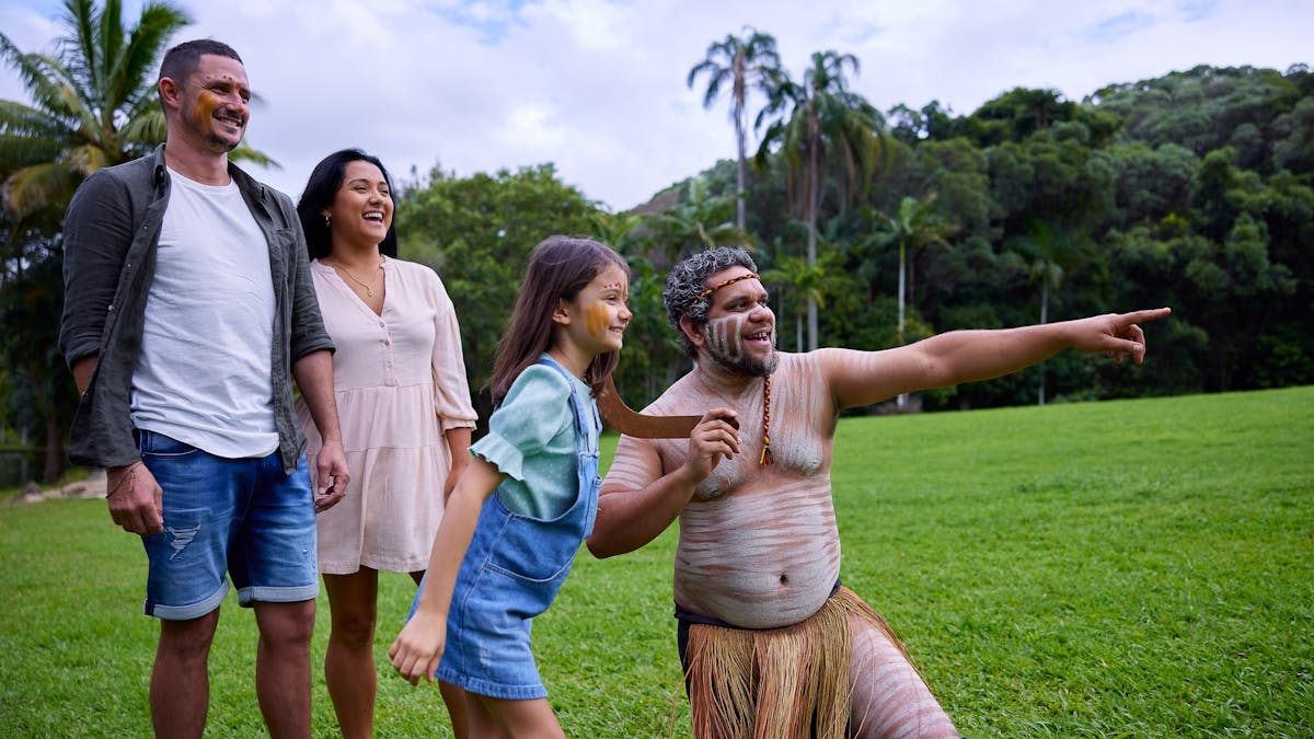 Pamagirri Aboriginal guide showing a family of three how to throw boomerang at Rainforestation