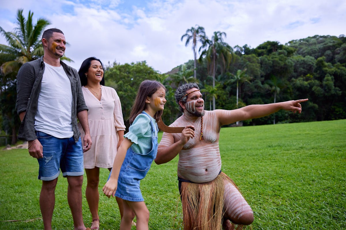 Pamagirri Aboriginal guide showing a family of three how to throw boomerang at Rainforestation