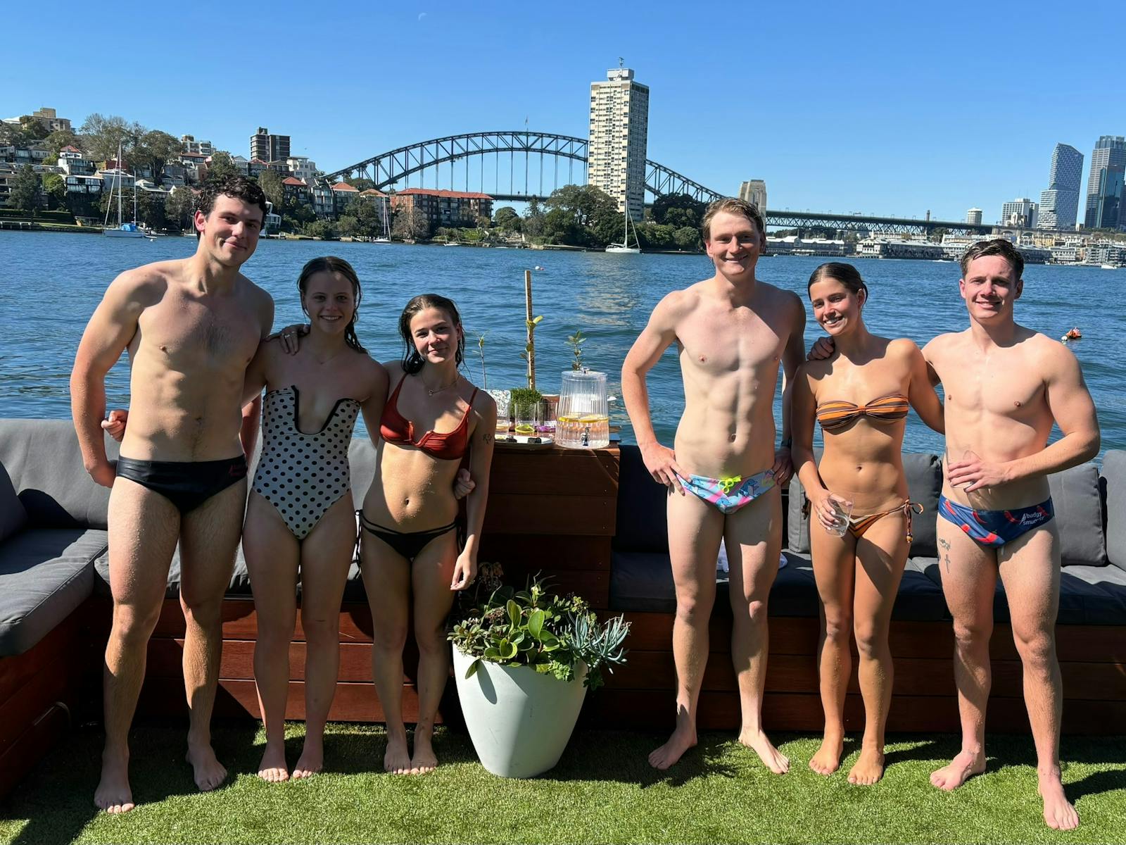 A mix of girls and guys in their swimming costumes with the Harbour Bridge in the background
