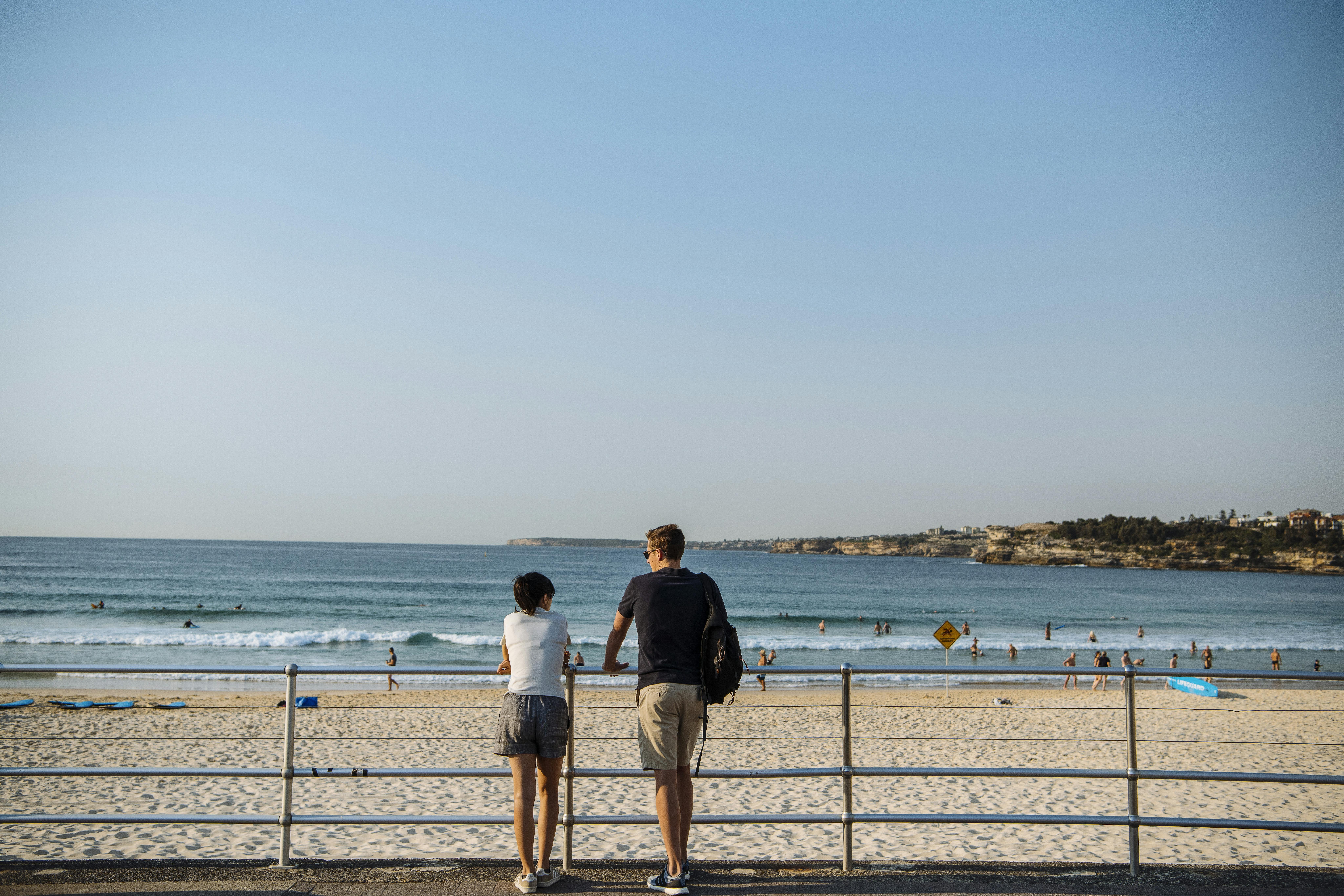 Couple enjoying a walk along Bondi Beach, Sydney.