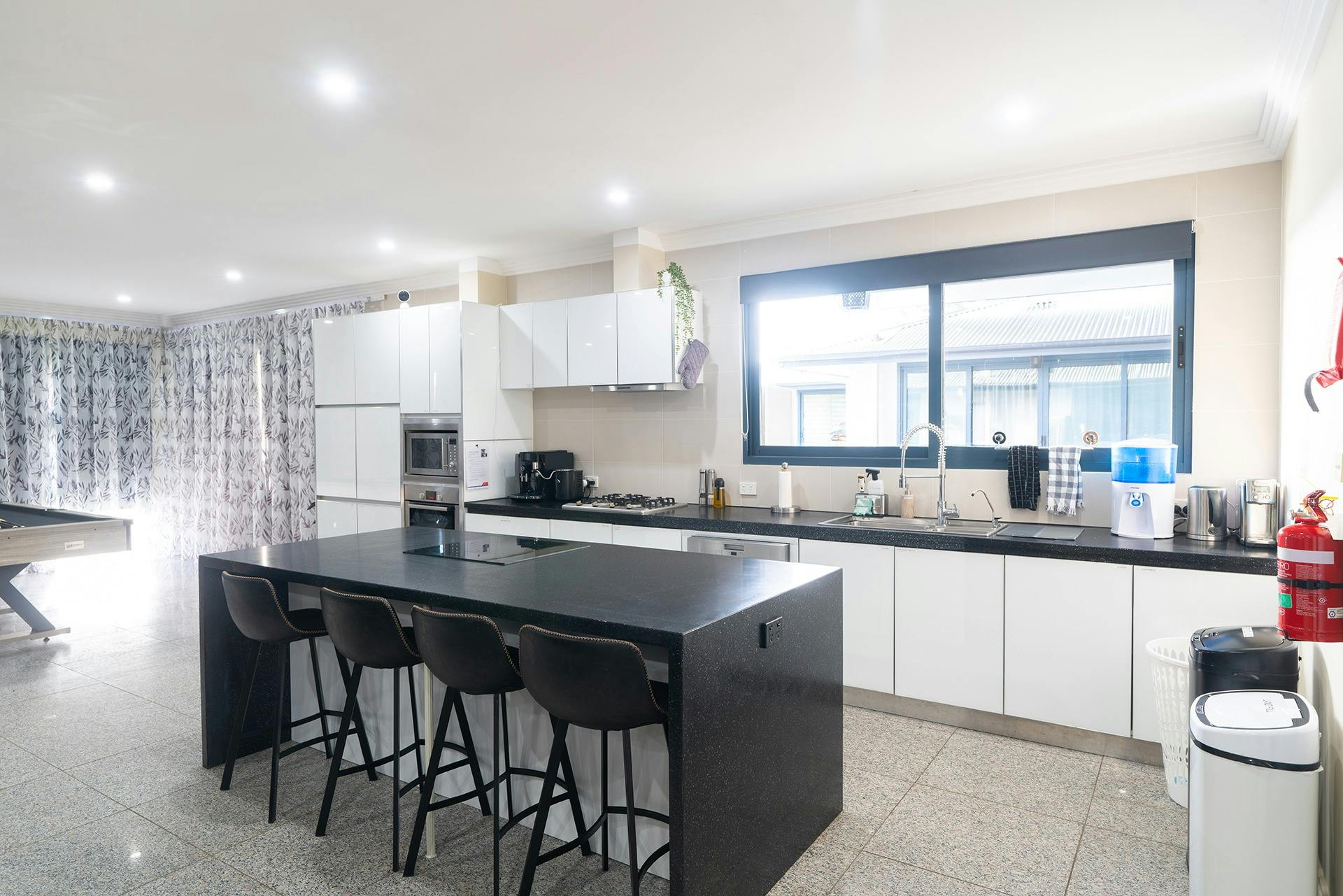 Galley style kitchen with 4 bar stools, coffee machine, water cooler and cooking equipment available