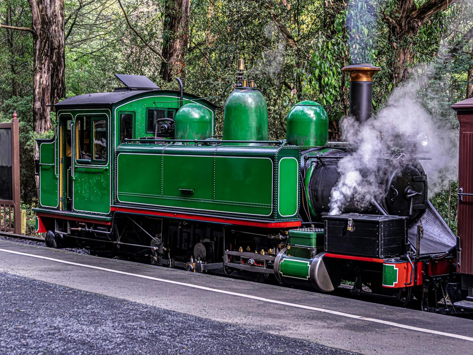 Close up of Green Puffing Billy steam train preparing for departure