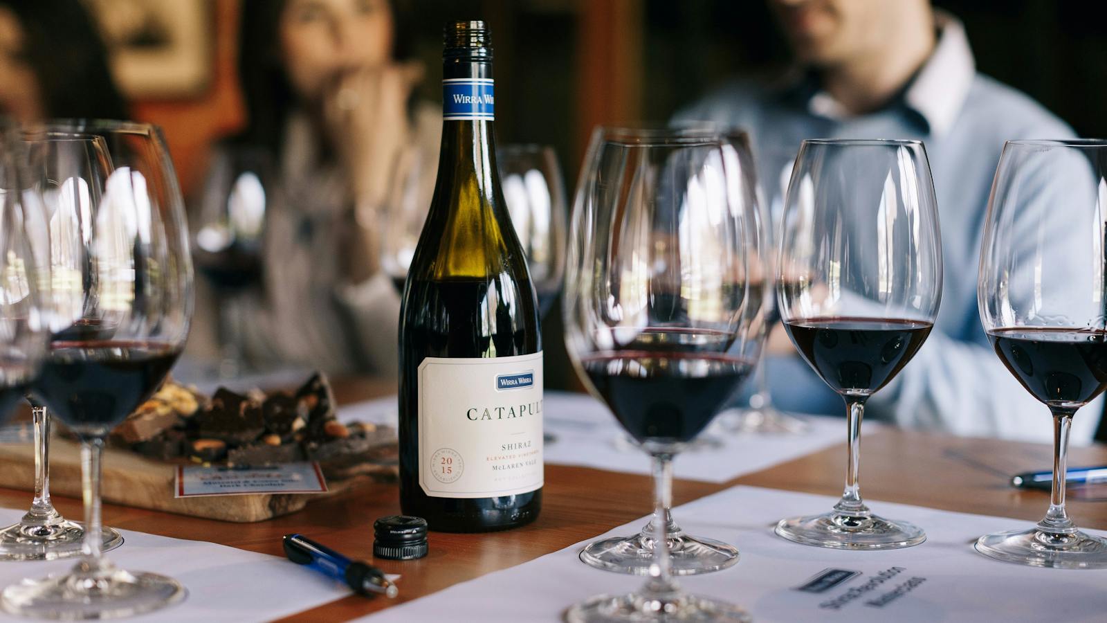 Glasses are laid out for a wine tasting with tasting mats.