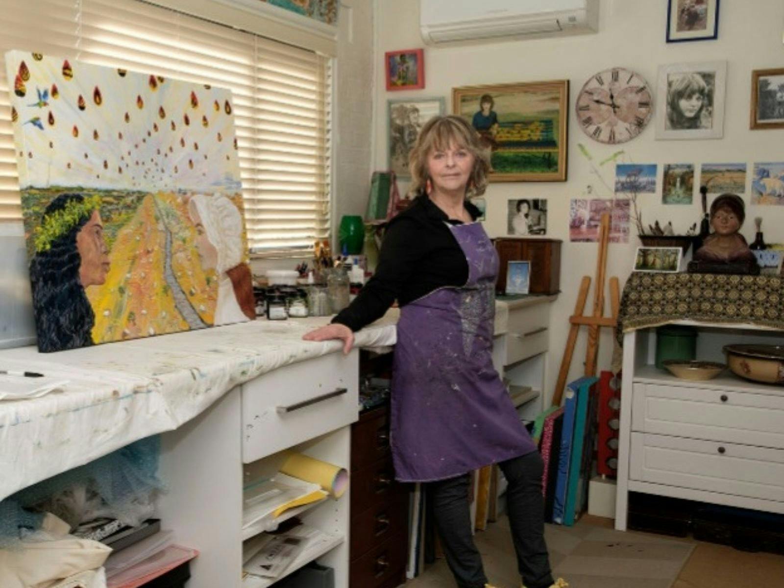 an artist standing next to artwork