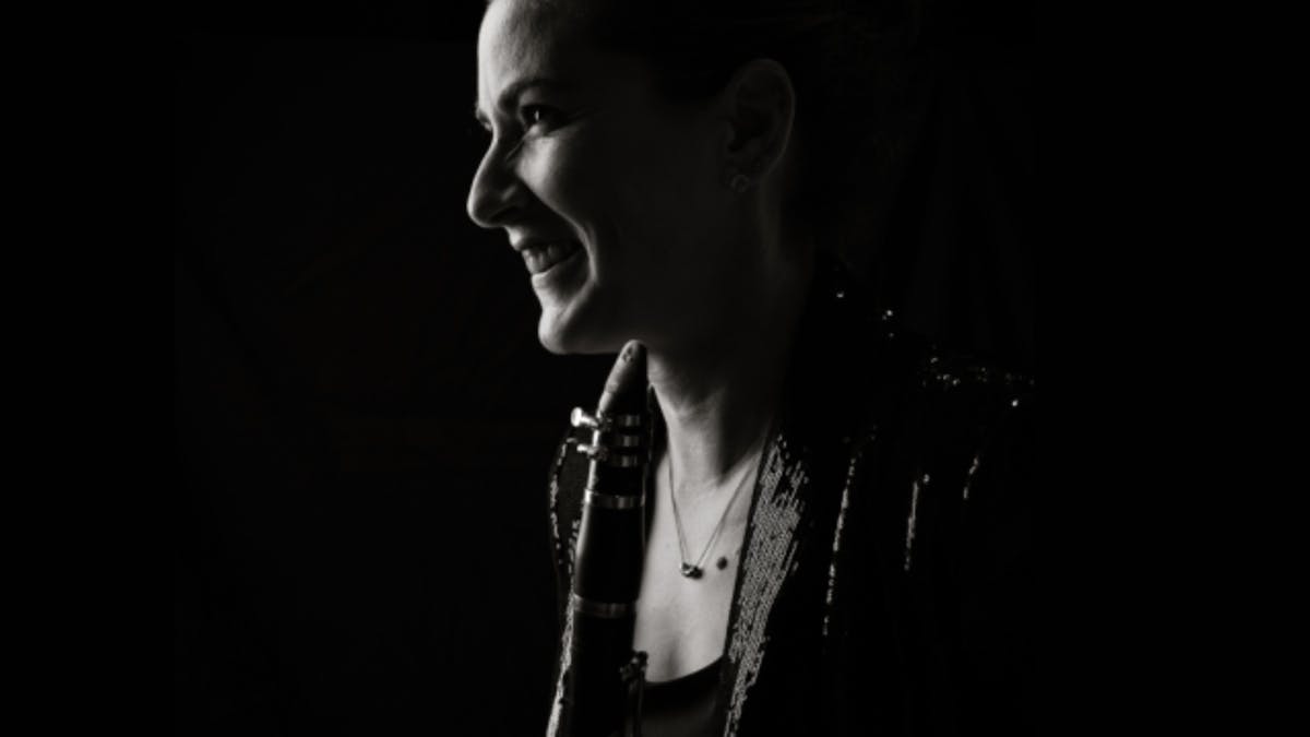 Black-and-white portrait of a clarinet player in profile, looking toward the light