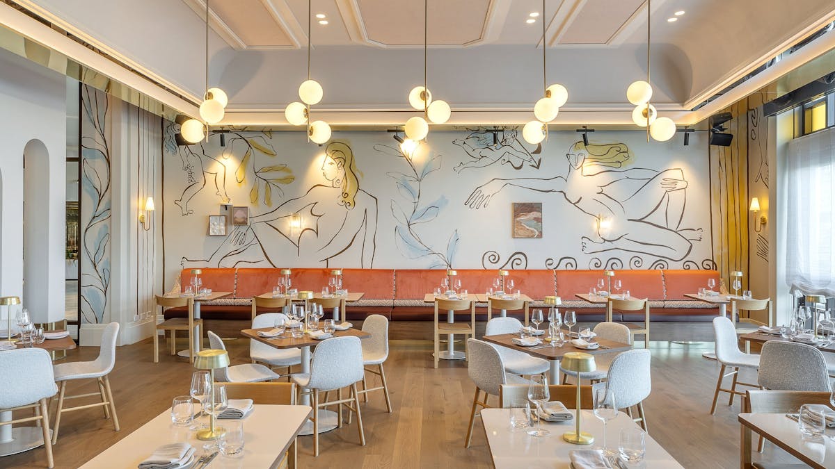 The dining room of Cucina Regina, with Italian murals on the walls