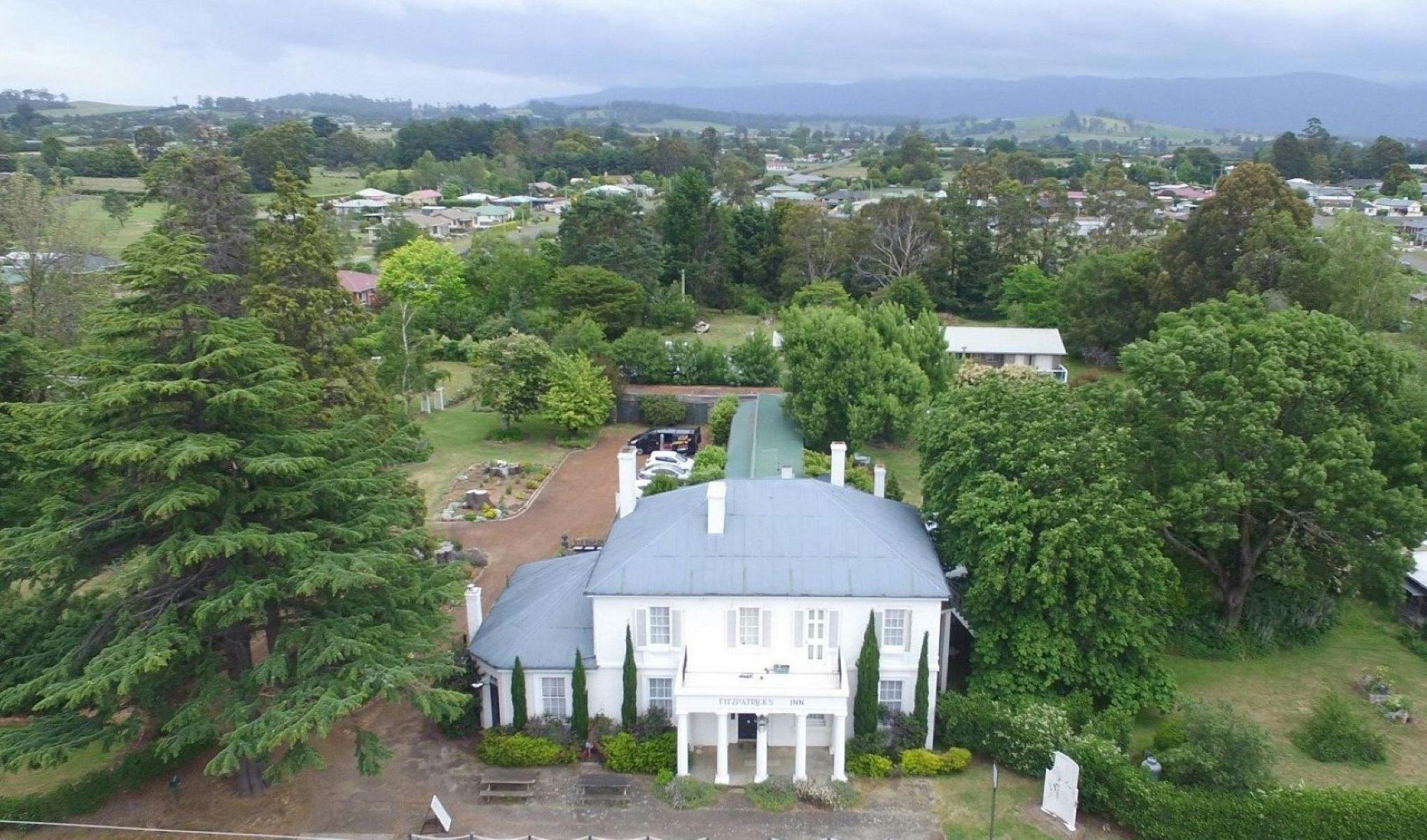 Front exterior of historic white building & gardens