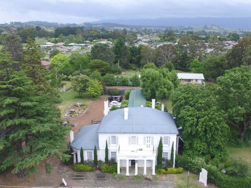 Front exterior of historic white building & gardens