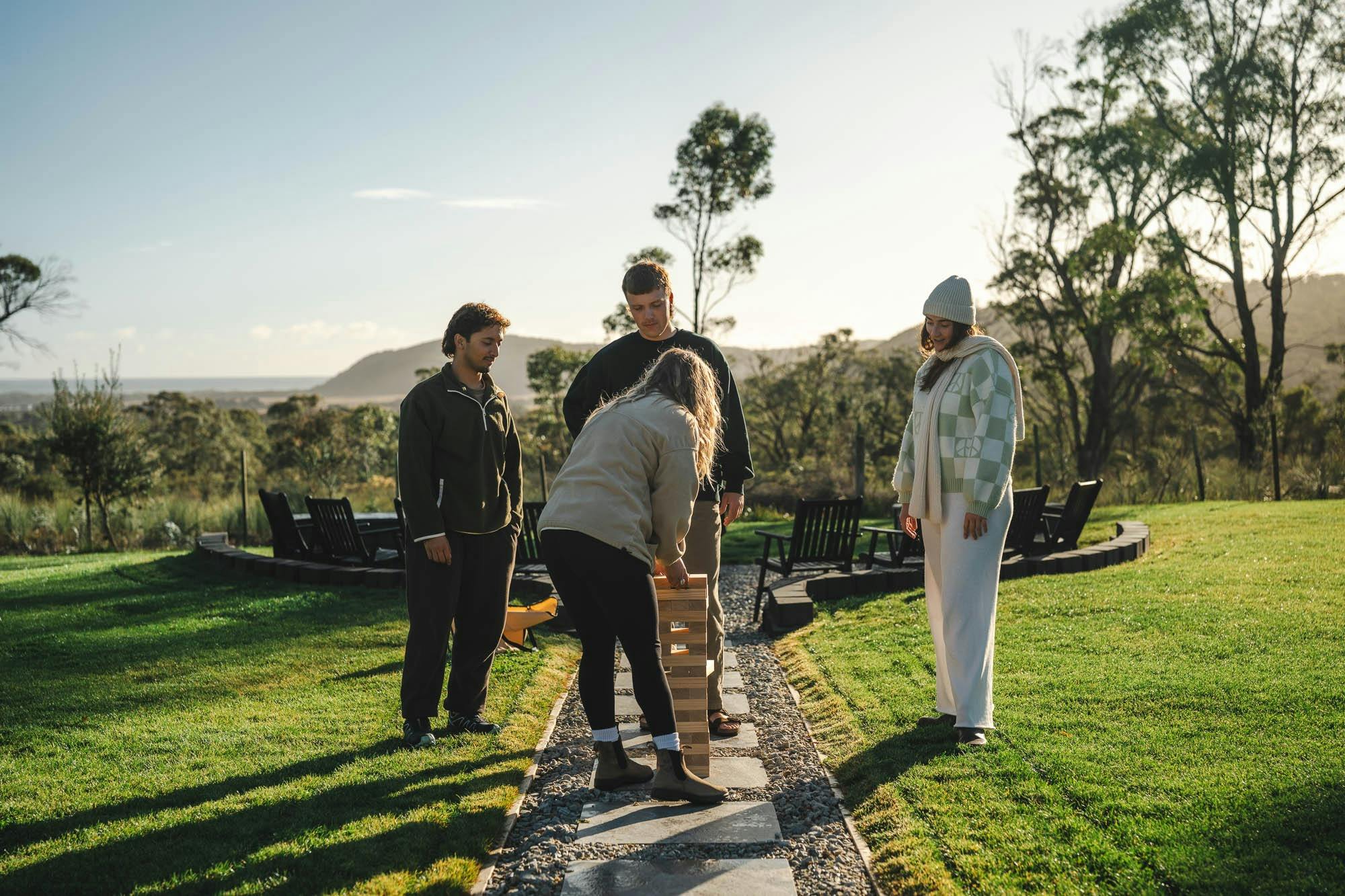 A group of guests standing on the lawn, socialising outside the lodge on a sunny day.