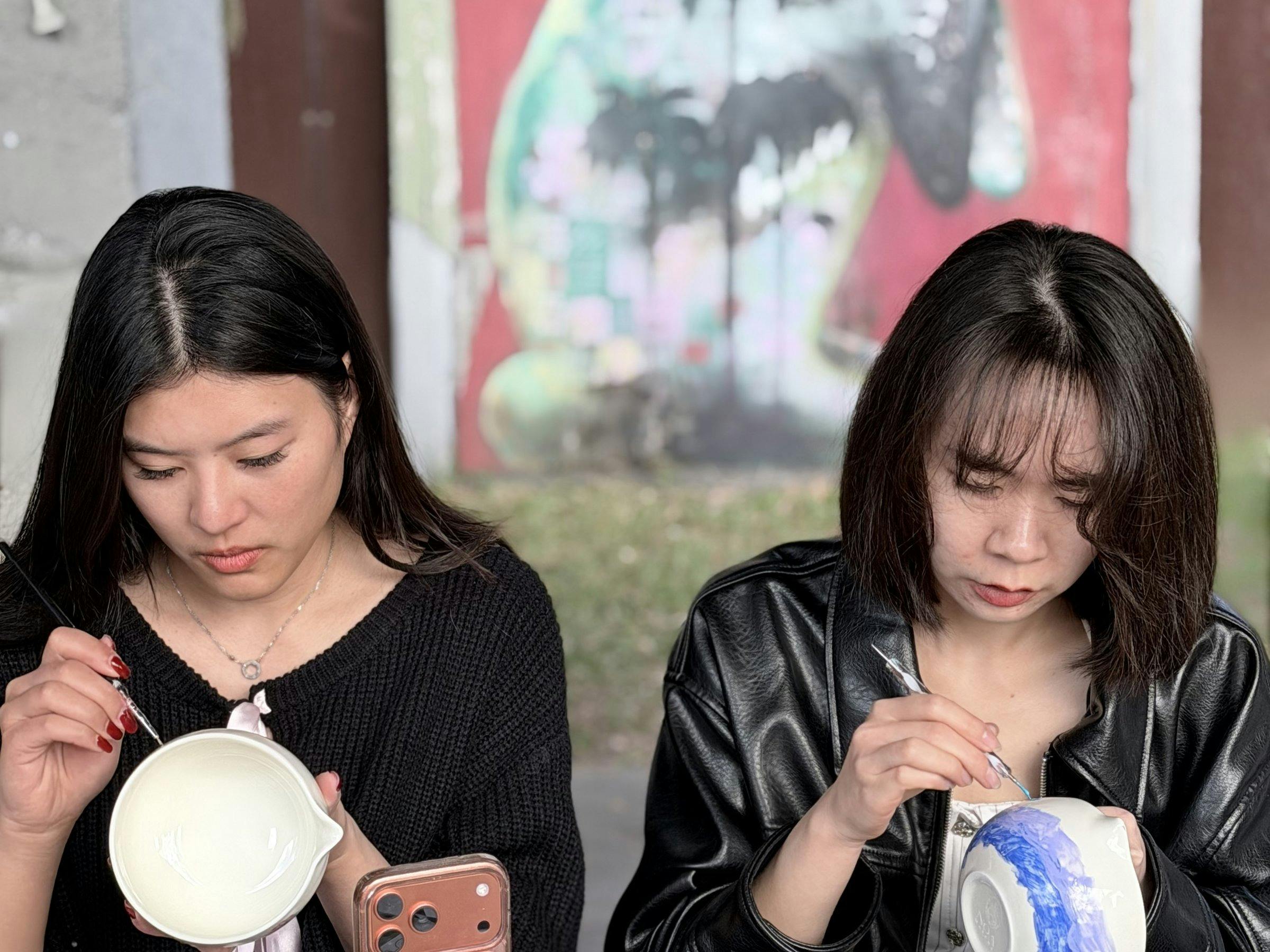 Guests holding their hand-painted ceramics at a NOA Matcha workshop