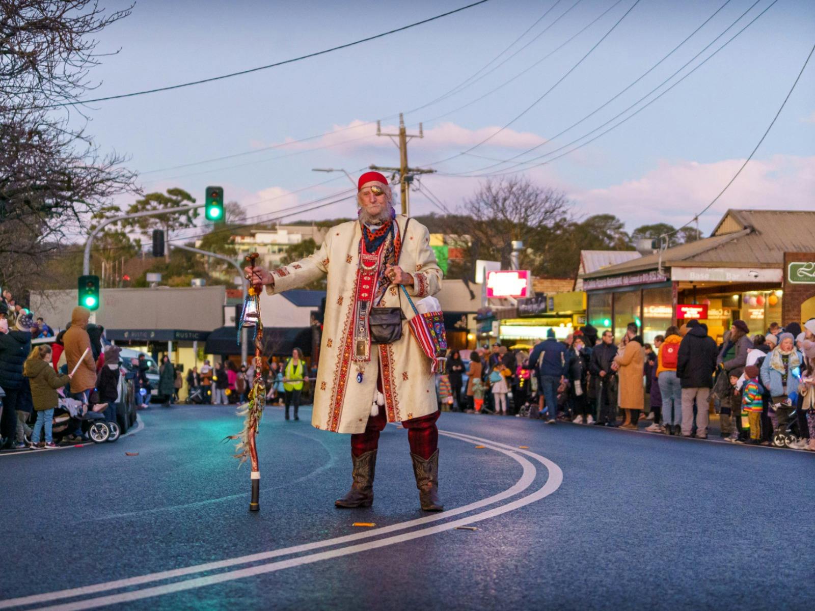 A wizard in colourful dress leads a street lantern parade