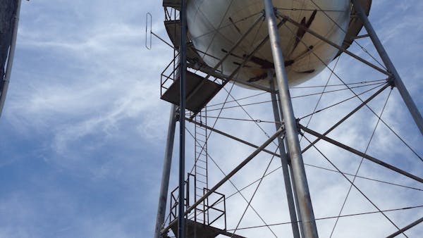 The view looking up from underneath a large, round water tower