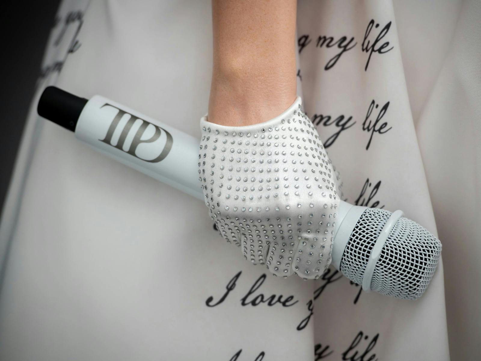 Taylor Swift's white crystal embellished gloves and bespoke microphone created by Rebel Stage Gear