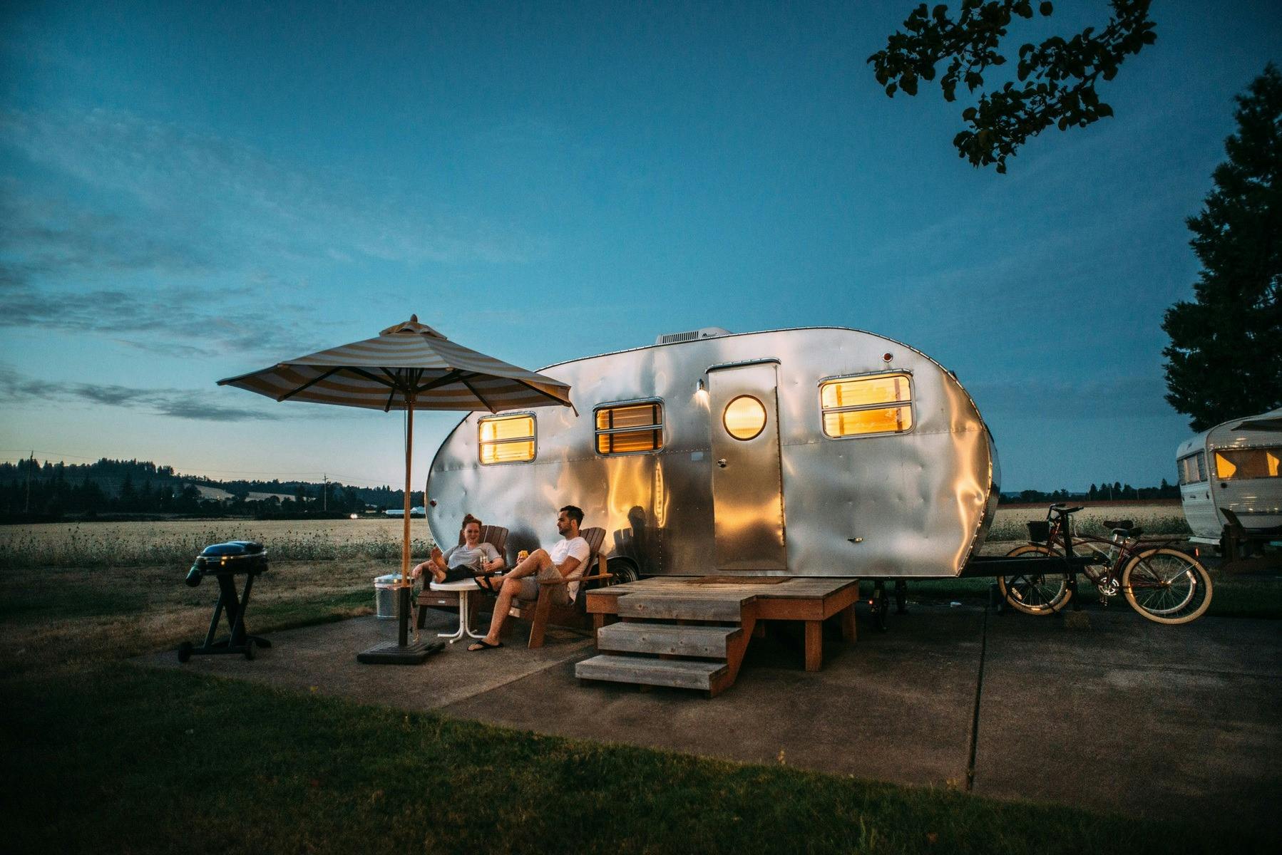 @ people sat outside caravan/tiny home