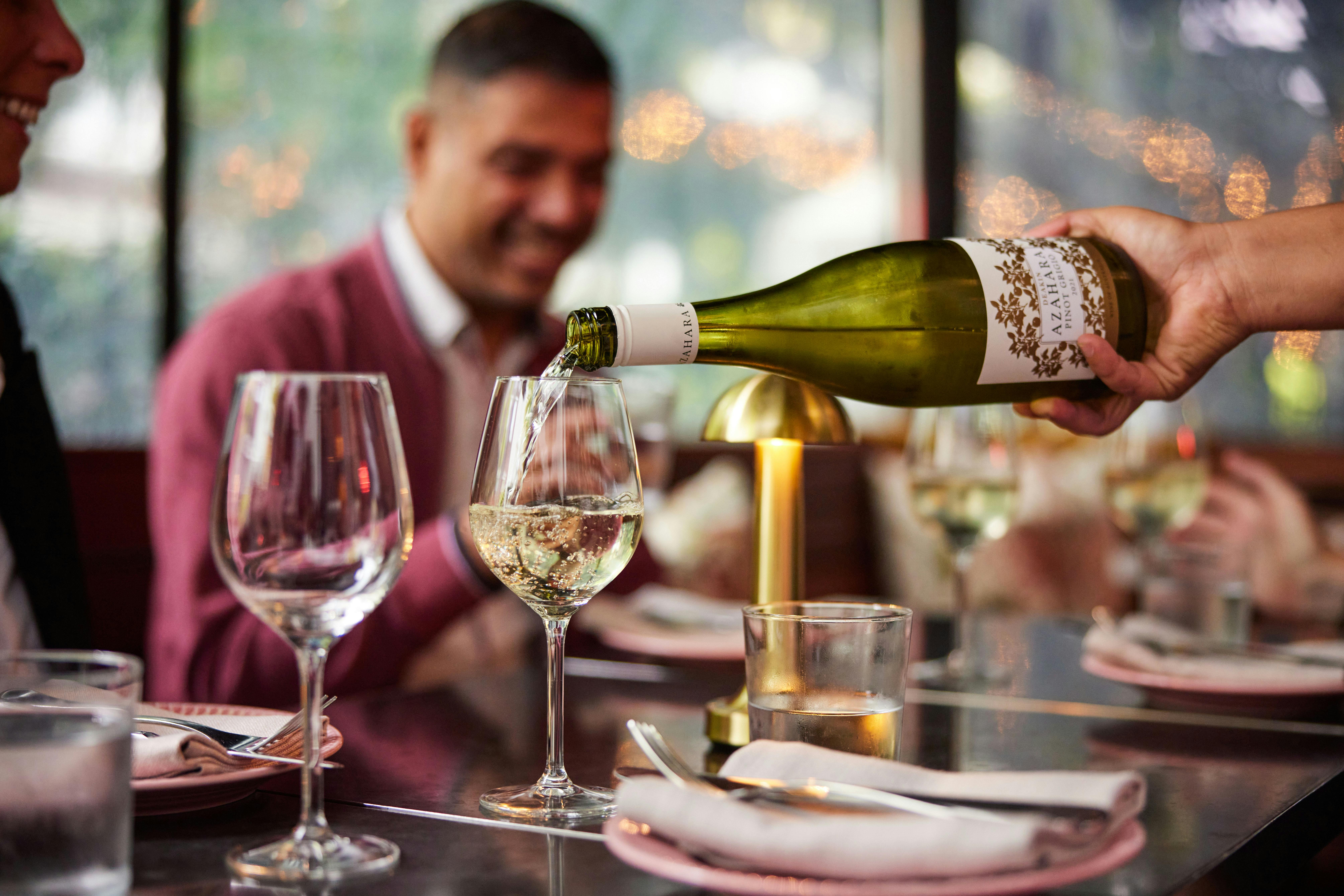 Guests chink glasses of wine at outdoor dining area