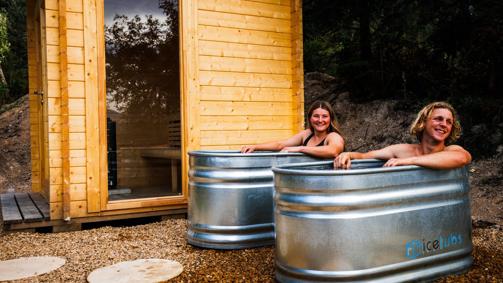 A couple enjoying a cold plunge next to sauna at maydena bike park