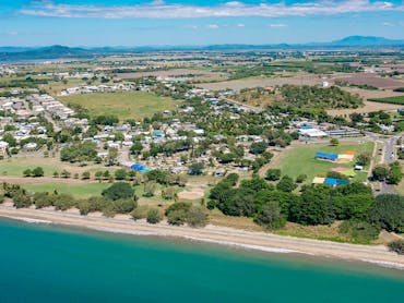 Aerial view of the coastal town of Bowen featuring a beach in the foreground.
