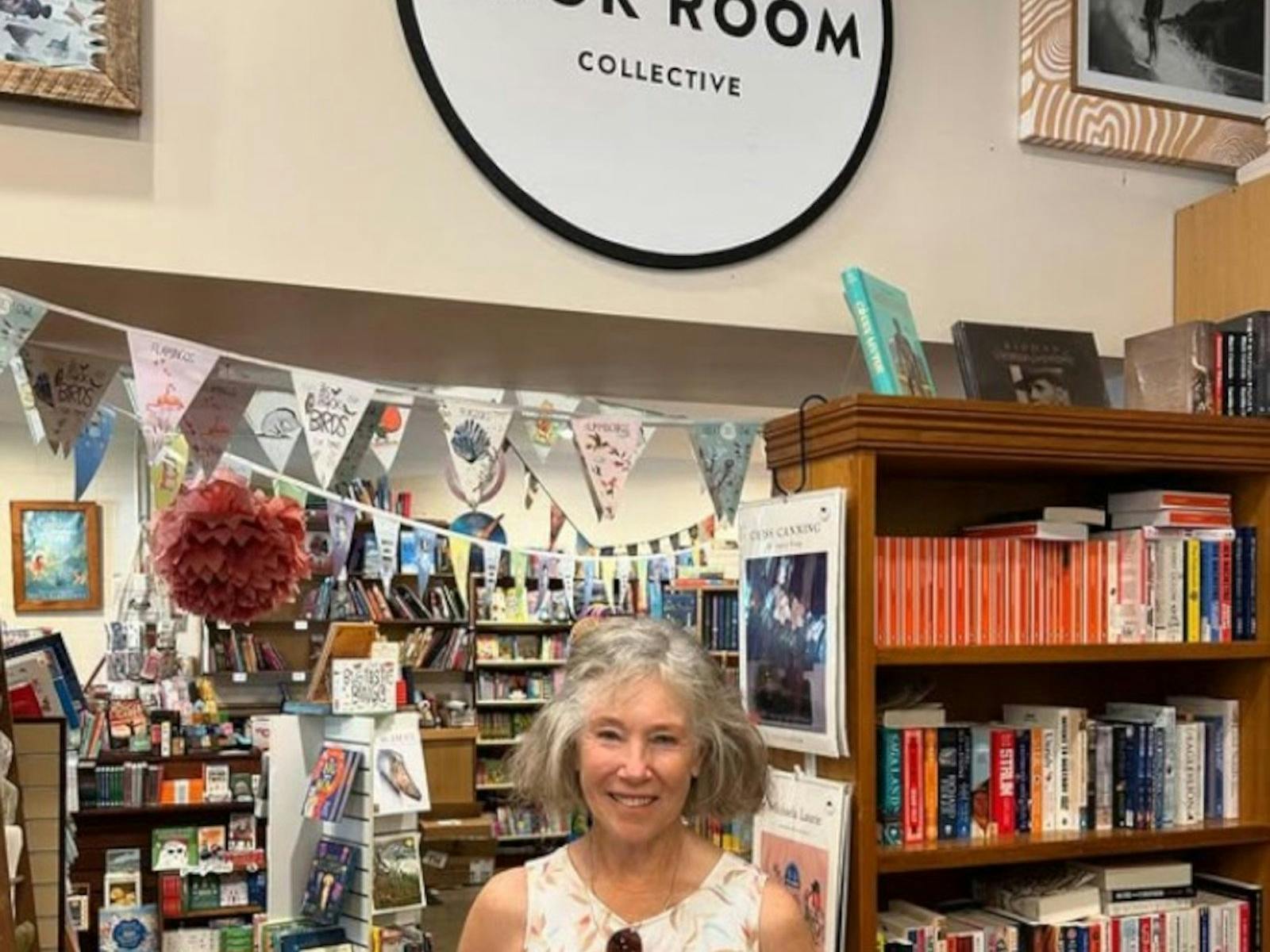 a happy author holding her book and smiling in the shop