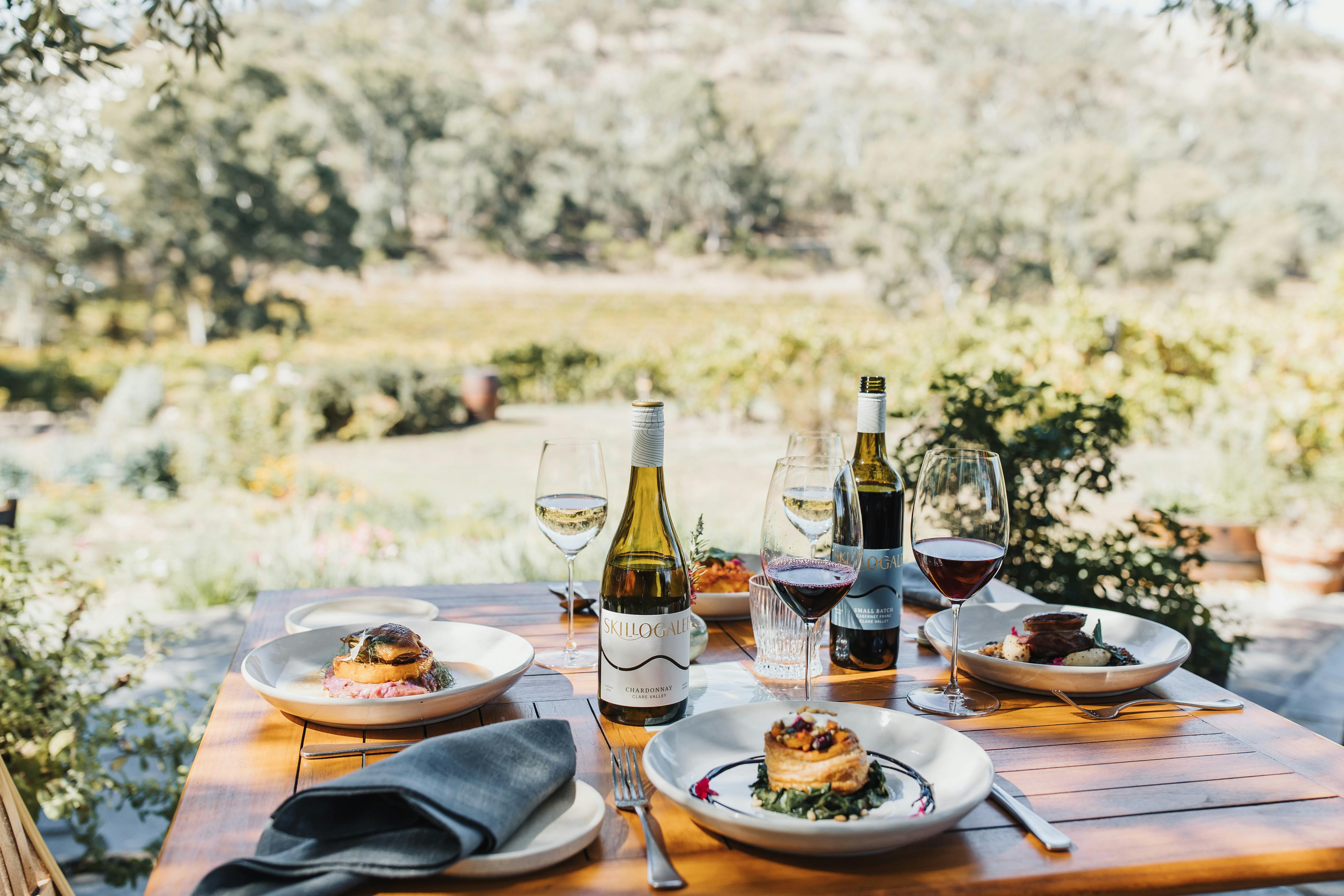 A table setting with food and wine overlookign vineyards