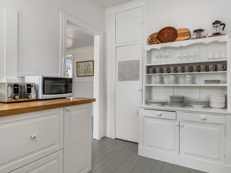 Kitchen with walk-in pantry, grey, white and timber decor.